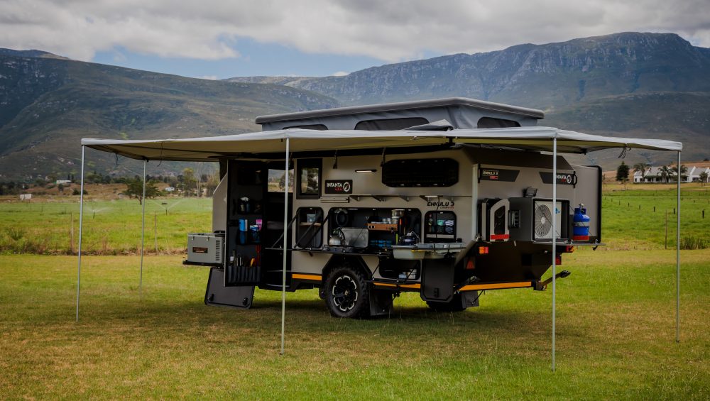 Photo of the Infanta 4x4 Enkulu 3 4x4 caravan for sale on a green field against mountains