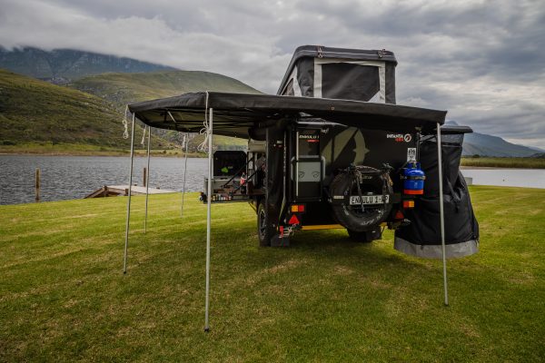 Image of the Infanta 4x4 Enkulu 1 off-road caravan that is set up by a lake in South Africa