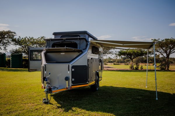 A front shot of the Infanta 4x4 Enkulu 2 caravan with awning out in beautiful nature