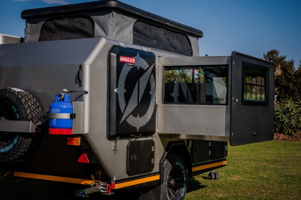 A close up Photo of an Infanta 4x4 Enkulu 2 off road Caravan for sale that is set up. Taken from a diagonal view