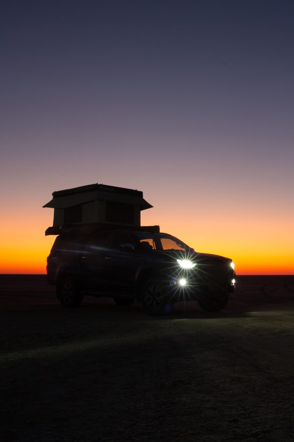 Buntutop tent from Bundutec on top of a vehicle on the beach in South Africa at sunset