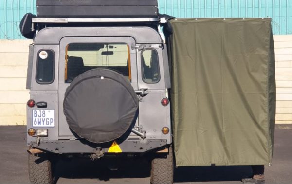A Bunducube attached to a vehicle from Bundutop next to a tree